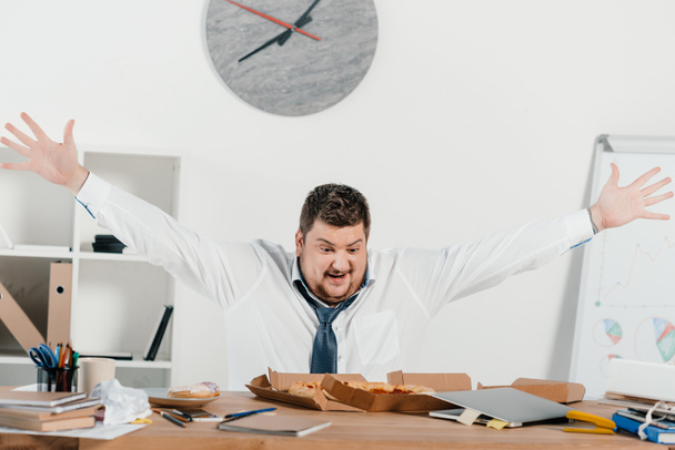 overweight excited businessman with pizza at workplace in office - Foto, imagen