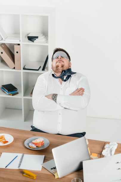 grasso uomo d'affari in maschera di sonno rilassante sul posto di lavoro
 - Foto, immagini