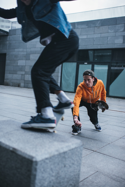 skateboarder taking photo of his partner doing trick - Foto, Bild
