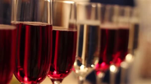 Glasses with alcohol drinks, glasses of wine and champagne are on the buffet table, red wine in glasses, champagne by the glass, buffet table with alcohol in a restaurant, New Year, Christmas - Metraje, vídeo