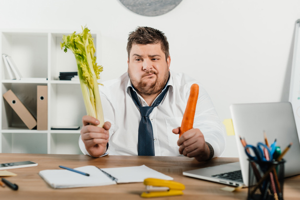 запутанный толстый бизнесмен смотрит на свежие овощи
  - Фото, изображение