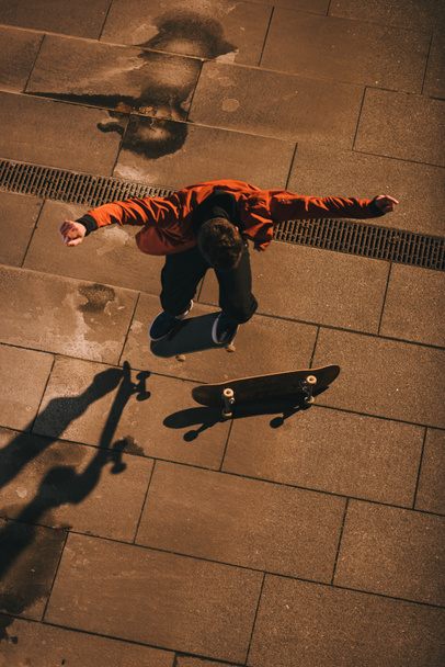 high angle view of skateboarder jumping over board - Valokuva, kuva