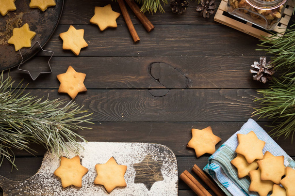 Galletas de Navidad en forma de estrellas sobre un fondo de madera oscura. Lugar para el texto
. - Foto, Imagen