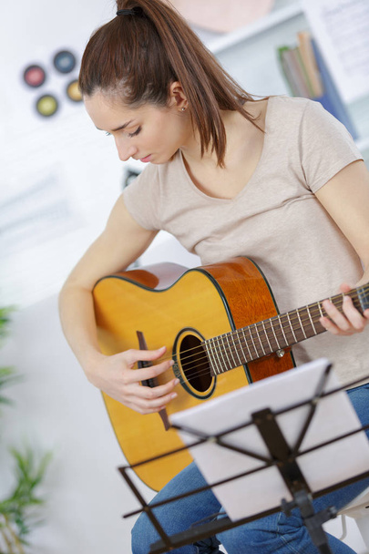 young woman strumming a guitar - 写真・画像