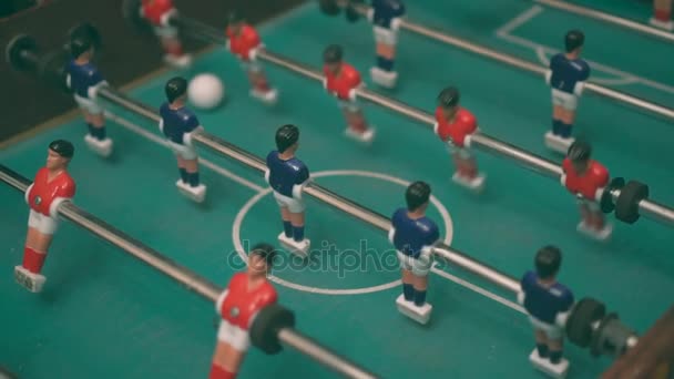 Люди играют в настольный футбол с красными и синими игроками
. - Кадры, видео