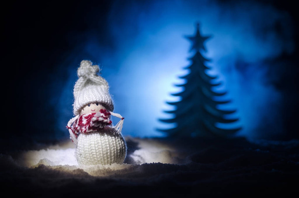 Szczęśliwy lalka Santa Claus na Boże Narodzenie w drzewa i śnieg. Bokeh kolorowe tło. Śnięty Mikołaj i Wesołych Świąt zabawka rysunek modelu na ciemnym stonowanych - Zdjęcie, obraz