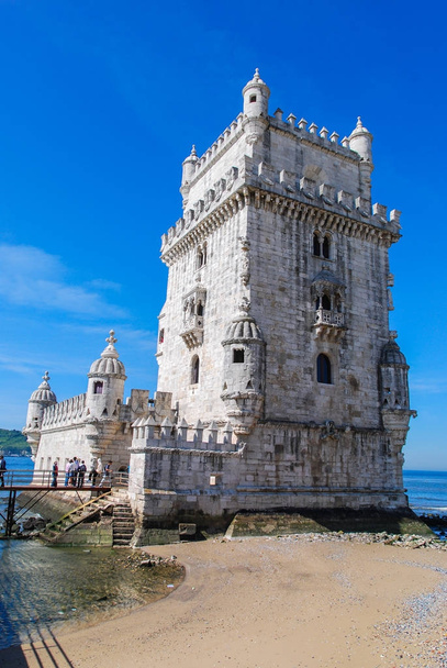 Torre Belem en Lisboa, Portugal aislado con turistas en frente y el océano Atlántico en el fondo
 - Foto, Imagen