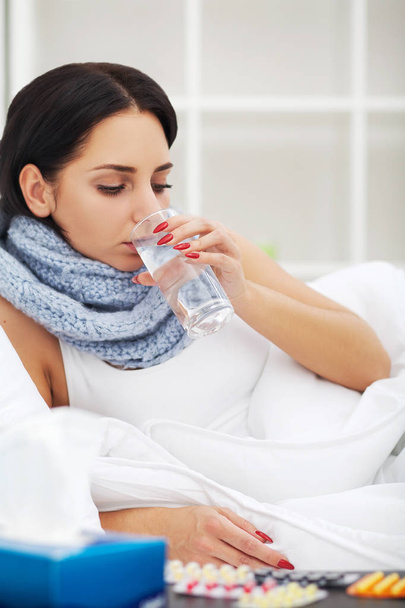 Mulher com nariz espirrando usando tecido na cama sofrendo gripe fria
  - Foto, Imagem