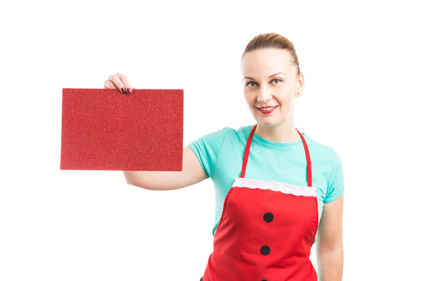 Mujer usando delantal sosteniendo cartón rojo
 - Foto, imagen