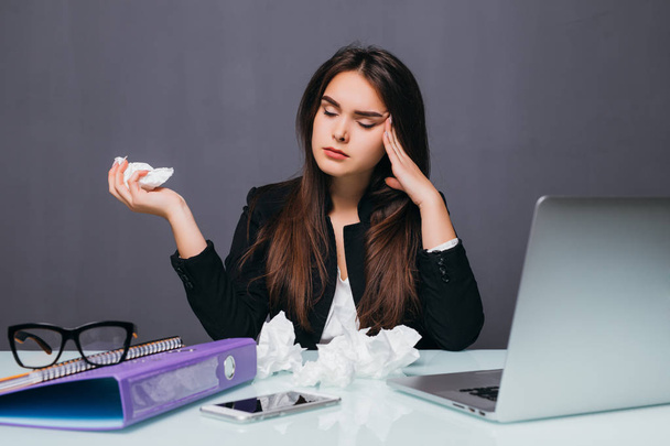 Молода бізнес-леді дме її ніс перед комп'ютером на столі з головним болем
 - Фото, зображення