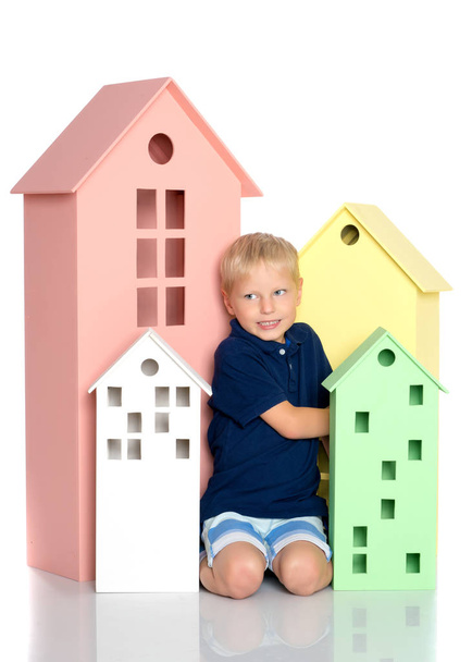 A little boy is playing with colorful houses. - Foto, imagen
