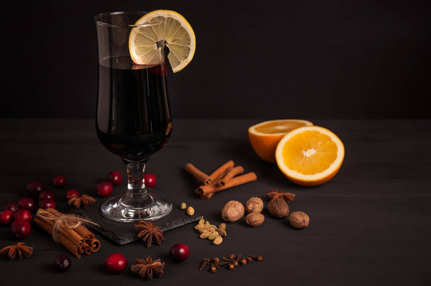 Glühwein, Heißgetränk mit Gewürzen auf schwarzem Hintergrund, Wein, Alkohol, Winter - Foto, Bild