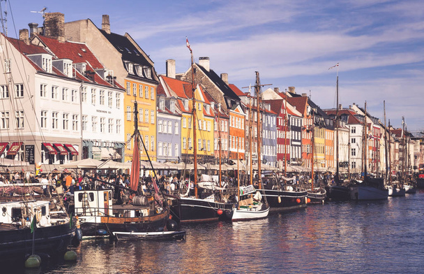 COPENHAGEN, DENMARK - SEPTEMBER 9: people in open cafes of the famous Nyhavn promenade on September 9, 2016 in Copenhagen, Denmark. Nyhavn is one of the most famous landmark of Copenhagen. - Foto, imagen