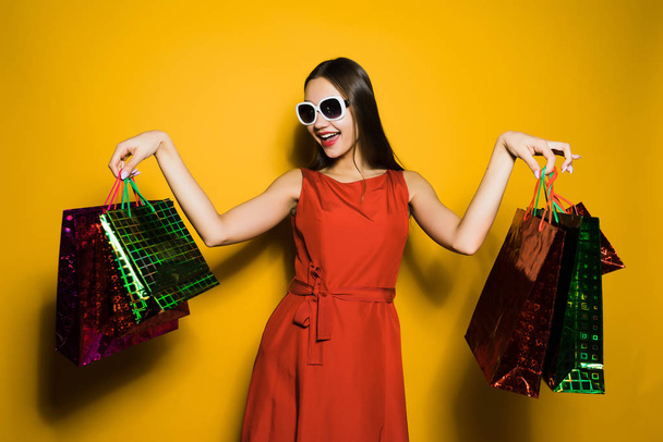a young stylish girl in sunglasses likes black Friday, went shopping, bought a lot of gifts for the new year - Foto, Imagen