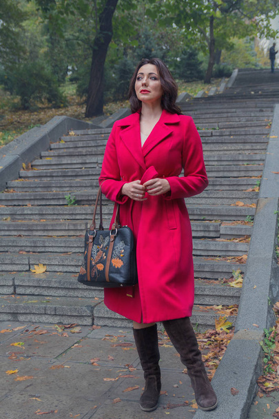 Hermosa mujer con un abrigo rojo en las escaleras. Gente
 - Foto, imagen