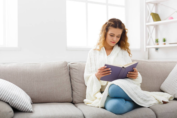 Cozy home. Young thoughtful woman with book - Foto, Imagem