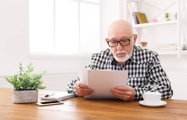 Senior man reading news on digital tablet - Фото, изображение