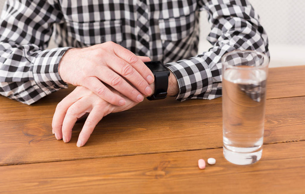 Старший чоловік руки зі склянкою води і таблетки
 - Фото, зображення