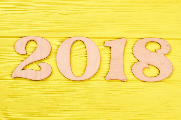 Ξύλινα αριθμό 2018 σε ξύλινα κίτρινο φόντο. - Φωτογραφία, εικόνα
