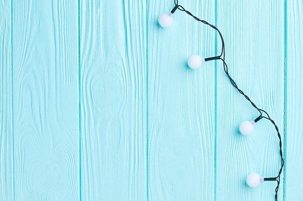 Christmas lights on blue wooden background. - Photo, Image