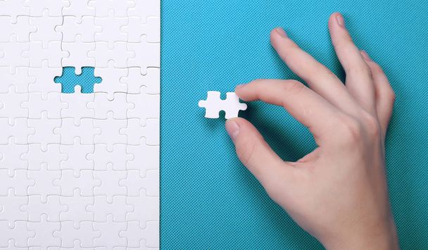 White details of a puzzle on green background. A puzzle is a puz - Photo, Image