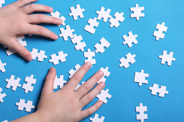 White details of a puzzle on a blue background. A puzzle is a pu - Foto, Imagem