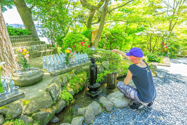femme adorant Jizo Statue
 - Photo, image
