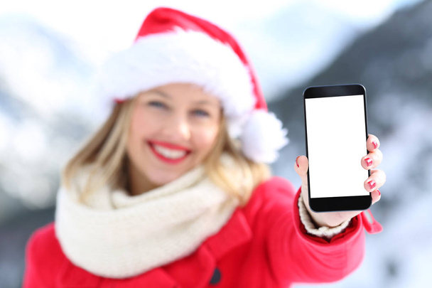 Girl on christmas holidays showing phone screen - Fotó, kép
