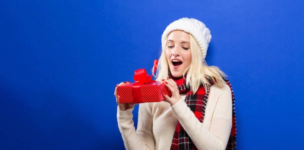 Young woman holding a Christmas gift - Foto, imagen