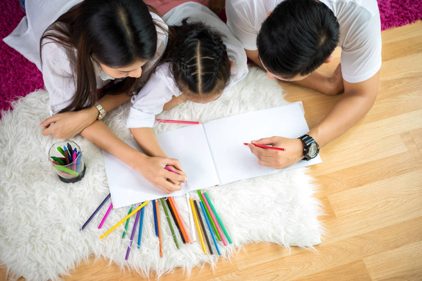Young family drawing together with colorful pencils at home - Foto, Imagem