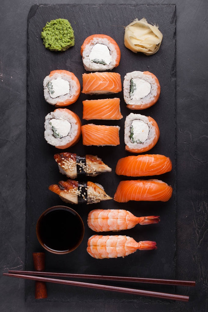 Sushi Set de sashimi au saumon, crevettes, anguilles et sushis en rouleaux philXoa servis sur ardoise de pierre. Vue du dessus
 - Photo, image