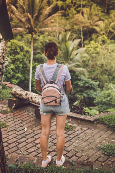 Atractiva joven mujer entre las plantas tropicales de vacaciones tropical de moda tiro en la selva tropical. Isla tropical de Bali, plams, borde, selva
. - Foto, Imagen