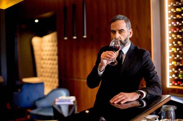 Handsome elegant businessman drinking red wine - Foto, Imagen