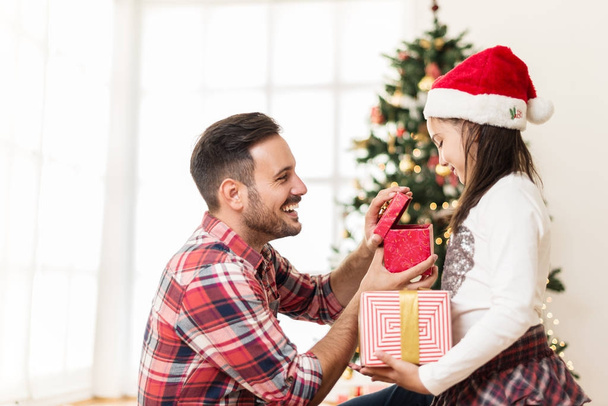 Father and daughter opening Christmas presents - 写真・画像