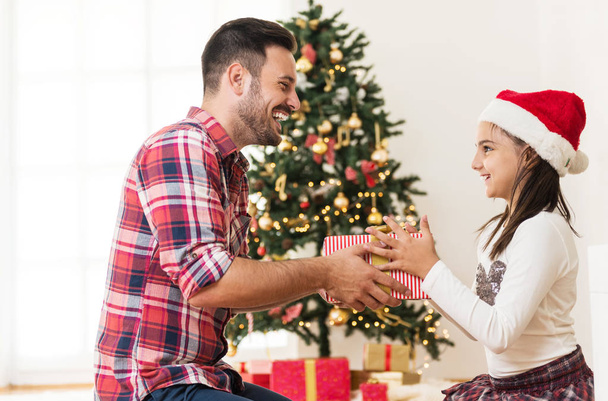 Father and daughter opening Christmas presents - Foto, imagen