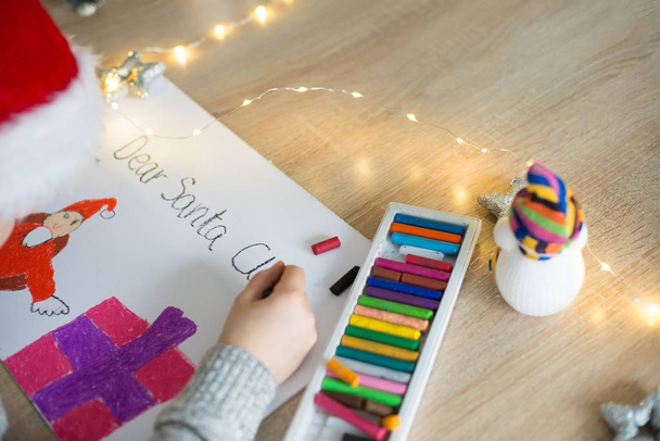 Child drawing a pastel drawing of Santa Claus - Photo, Image