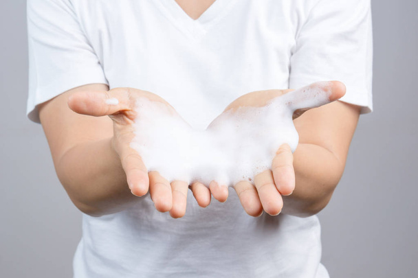 Gesto de una mujer lavándose las manos con jabón sobre fondo blanco
 - Foto, Imagen