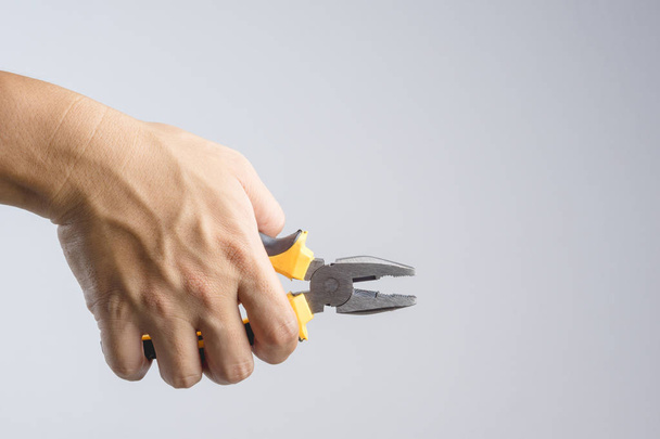 Hand holding needle nose or pointy pliers for universal repair and construction on white background - Fotoğraf, Görsel