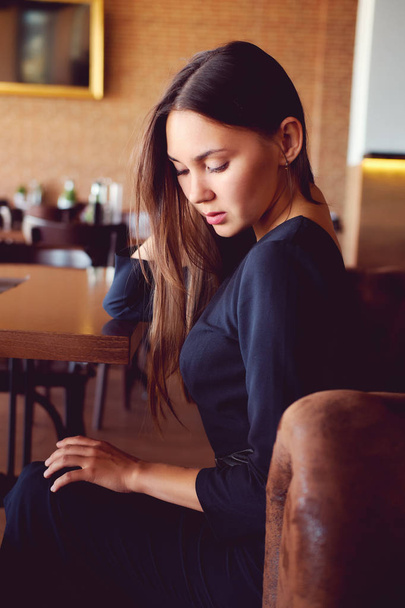 Young brunette sitting in a restaurant - Fotografie, Obrázek