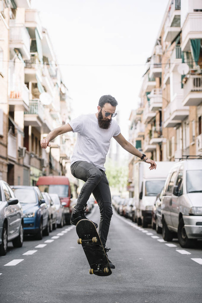 Młody skater boy Robienie sztuczek z jego skateboard street - Zdjęcie, obraz