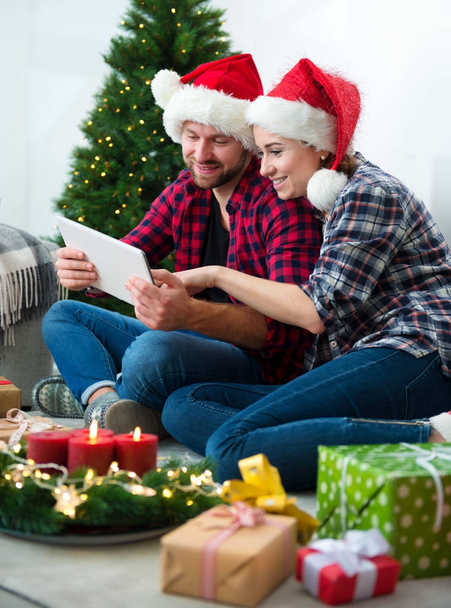Young couple with Santa Claus hats shopping online Christmas gif - Φωτογραφία, εικόνα