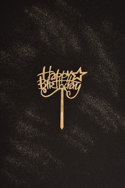 Draufsicht auf goldenes Happy Birthday Schild auf schwarzer Oberfläche - Foto, Bild