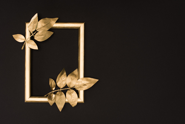 top view of golden photo frame and leaves isolated on black - Фото, зображення