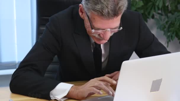 tired old businessman working with a computer in a modern office - Footage, Video