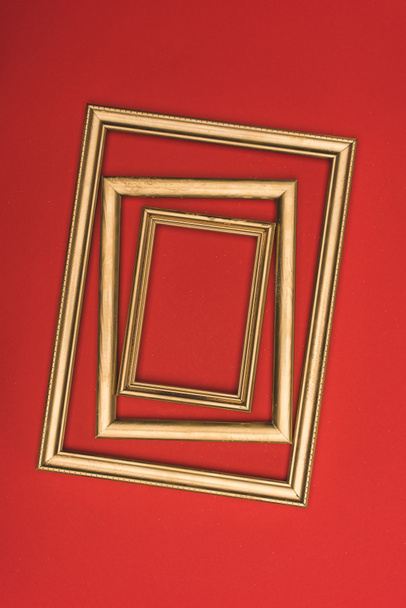 top view of arranged of golden photo frames isolated on red - Photo, Image