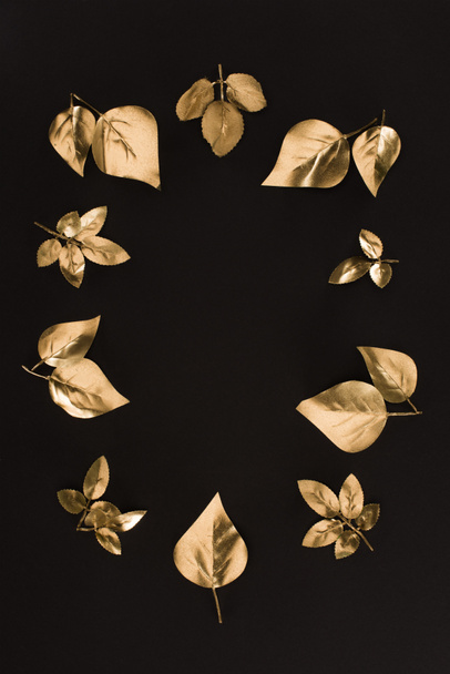 top view of various golden leaves arrangement isolated on black - Fotó, kép