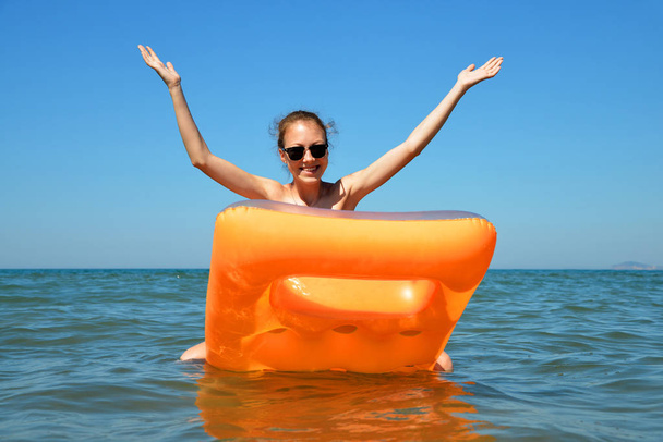 Chica joven flotando en el colchón inflable en el mar. Vacaciones de verano
. - Foto, imagen