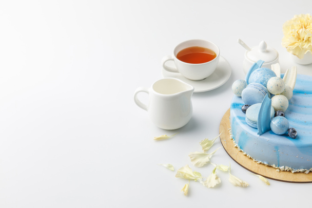 blue tasty cake on chopping board with cup of tea isolated on white - Fotografie, Obrázek