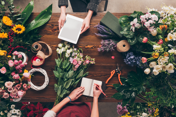 cropped image of florists with tablet and notebook at work - Photo, Image