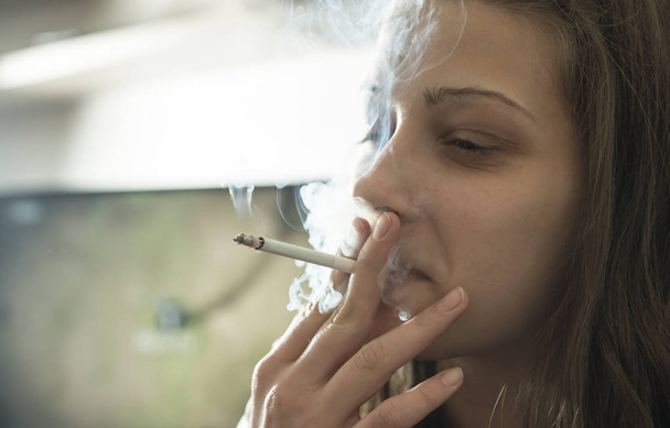Girl smoke cigarette in the house.  - Fotoğraf, Görsel